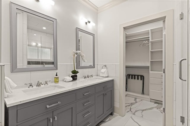 bathroom featuring crown molding, marble finish floor, a sink, and double vanity