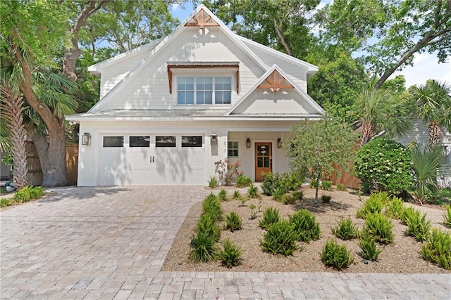 craftsman inspired home with decorative driveway and fence