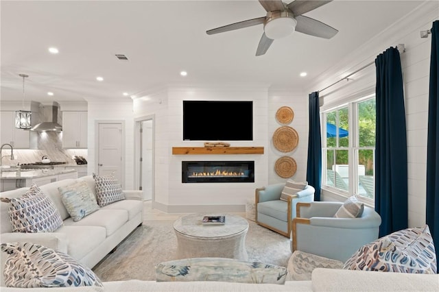 living area with visible vents, ceiling fan, crown molding, and recessed lighting