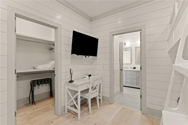 interior space with connected bathroom, a closet, and light wood-style flooring