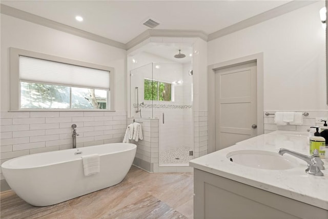bathroom with a shower stall, a sink, double vanity, visible vents, and a freestanding tub