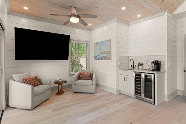 living area with wood ceiling, ceiling fan, light wood finished floors, indoor wet bar, and wine cooler