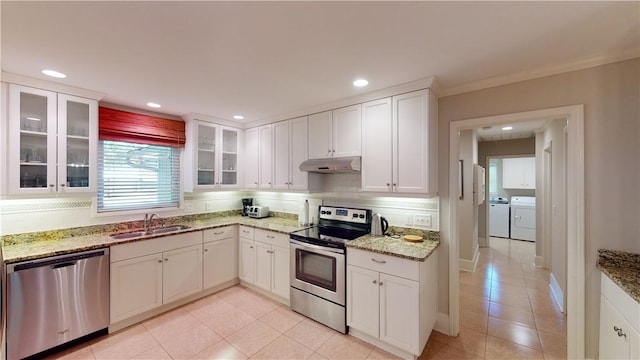 635 Old Plantation Rd, Jekyll Island, GA 31527 - kitchen with a sink, light tile patterned flooring, under cabinet range hood, washing machine and dryer, and appliances with stainless steel finishes