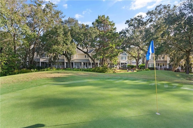 view of home's community with a lawn, a residential view, and golf course view