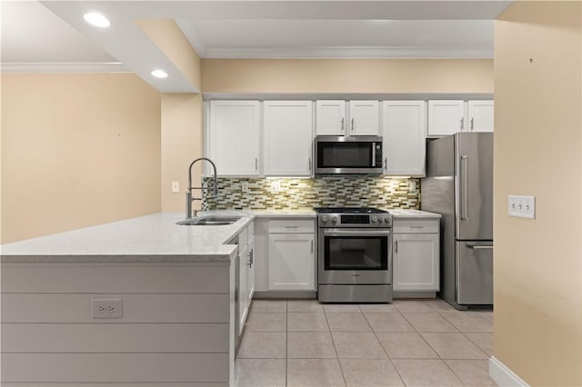 kitchen featuring a sink, stainless steel appliances, a peninsula, and white cabinetry