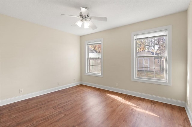 spare room with hardwood / wood-style floors, plenty of natural light, and ceiling fan