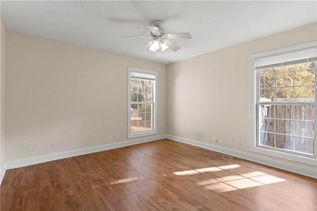 empty room with a textured ceiling, hardwood / wood-style flooring, and ceiling fan