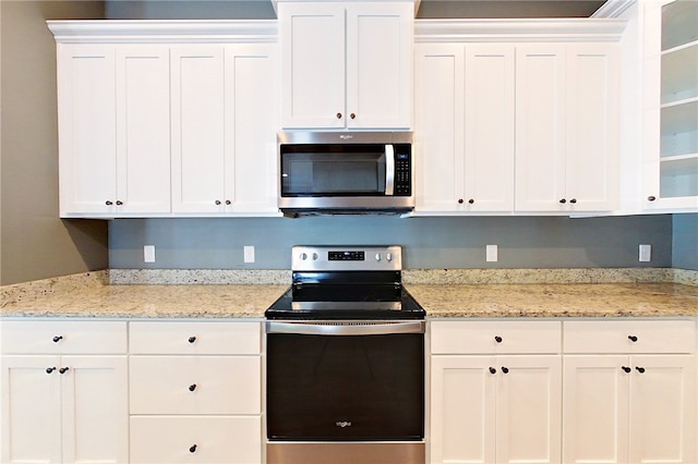 550 Freedom Trl, Brunswick, GA 31525 - kitchen with white cabinets, light stone counters, and stainless steel appliances
