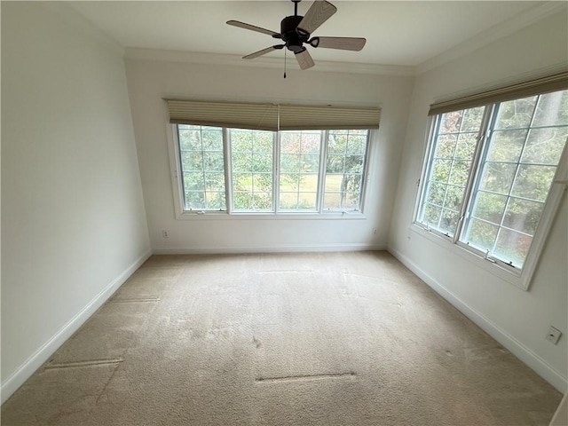 carpeted empty room with plenty of natural light, ceiling fan, and ornamental molding