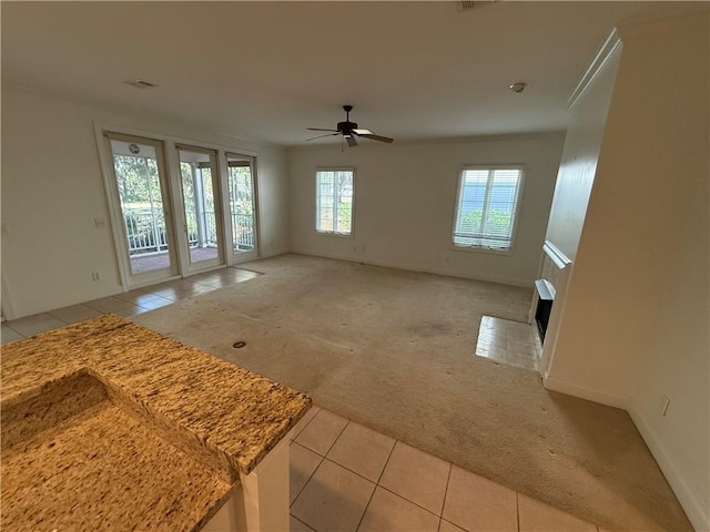 unfurnished living room featuring ceiling fan and light colored carpet