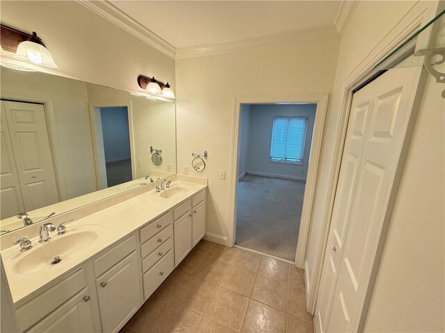 full bath with a sink, ornamental molding, and double vanity