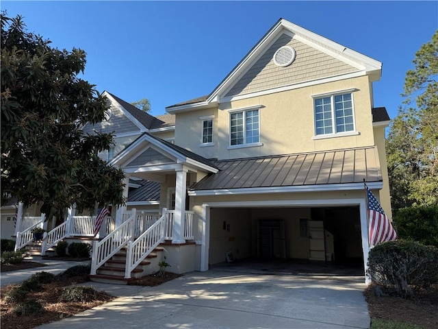 view of front of house with a garage, stucco siding, driveway, and a standing seam roof