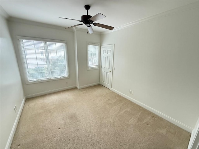 carpeted empty room featuring ceiling fan and ornamental molding