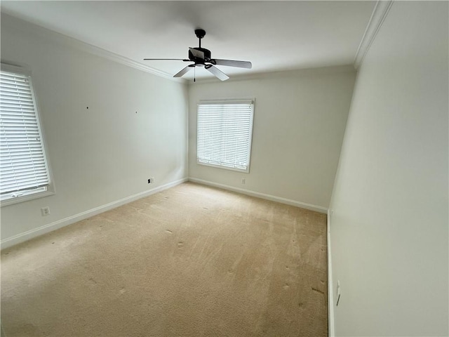 unfurnished room with ceiling fan, light colored carpet, and crown molding