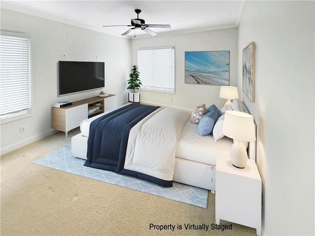 carpeted bedroom featuring baseboards, a ceiling fan, and crown molding