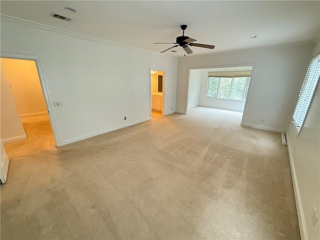 carpeted spare room with ceiling fan and ornamental molding