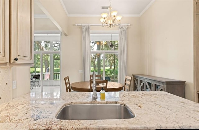 704 Dungeness, Saint Simons Island, GA 31522 - kitchen featuring a chandelier, light stone countertops, ornamental molding, and decorative light fixtures
