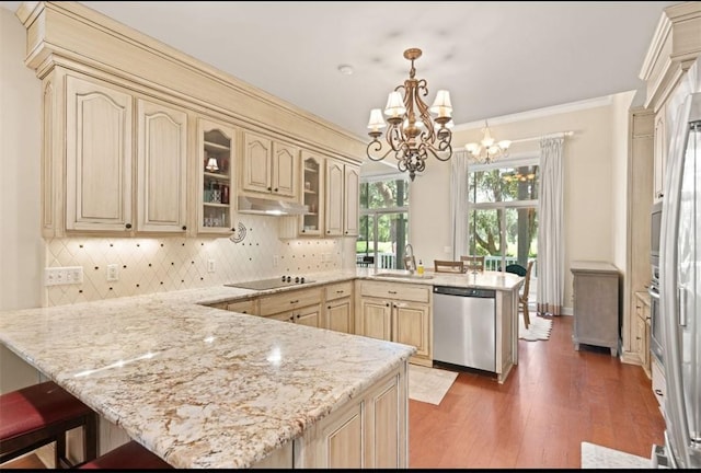 704 Dungeness, Saint Simons Island, GA 31522 - kitchen with stainless steel dishwasher, a peninsula, black electric cooktop, cream cabinetry, and under cabinet range hood