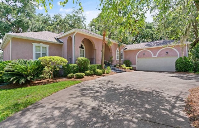 704 Dungeness, Saint Simons Island, GA 31522 - view of front of house featuring stucco siding, an attached garage, and concrete driveway