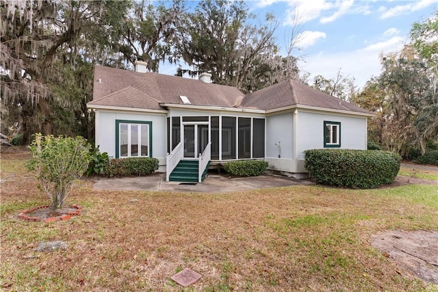 back of property with a patio area, a yard, and a sunroom