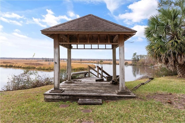 view of dock featuring a gazebo, a yard, and a water view