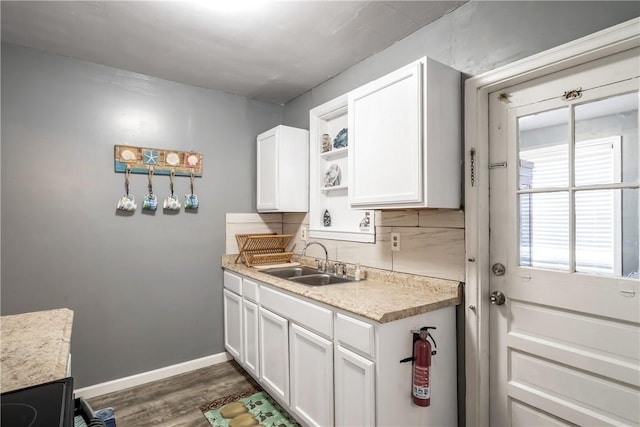 kitchen with a sink, white cabinets, light countertops, decorative backsplash, and open shelves