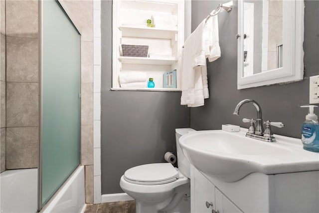 full bathroom featuring toilet, shower / bath combination with glass door, and vanity