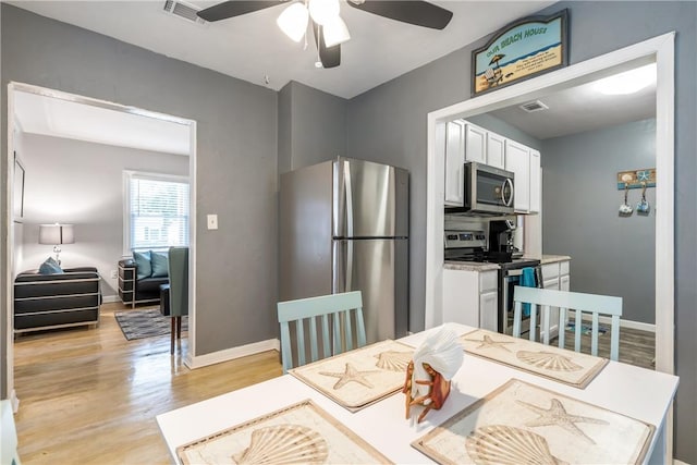 dining space featuring visible vents, ceiling fan, light wood-style flooring, and baseboards