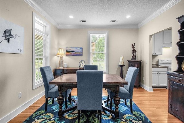 800 Wayne St, Darien, GA 31305 - dining area with light wood-style flooring, a textured ceiling, baseboards, crown molding, and recessed lighting