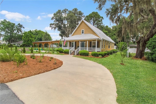 800 Wayne St, Darien, GA 31305 - farmhouse-style home featuring covered porch, a front yard, curved driveway, and metal roof