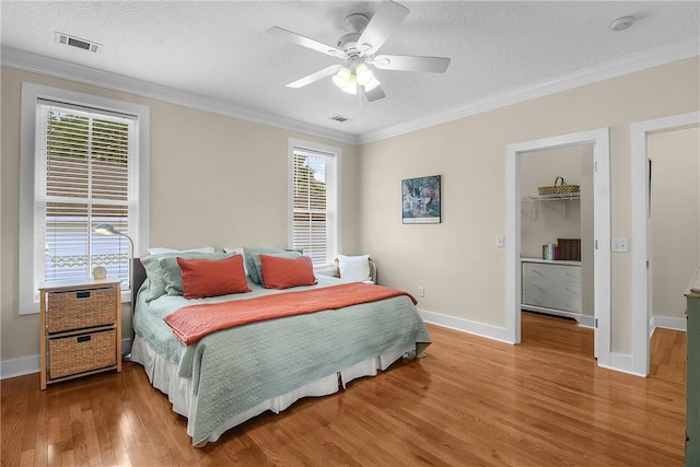 800 Wayne St, Darien, GA 31305 - bedroom featuring wood finished floors, a textured ceiling, multiple windows, baseboards, and ornamental molding