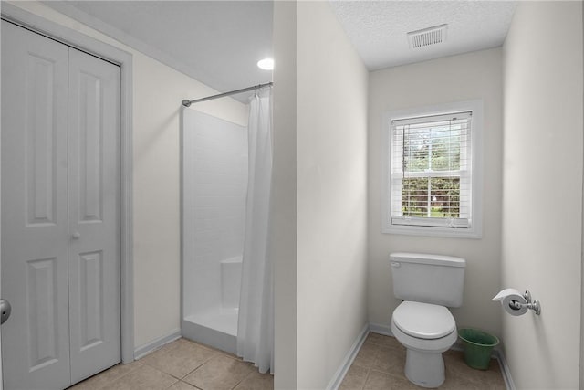 800 Wayne St, Darien, GA 31305 - bathroom with baseboards, a shower with curtain, toilet, tile patterned flooring, and a textured ceiling