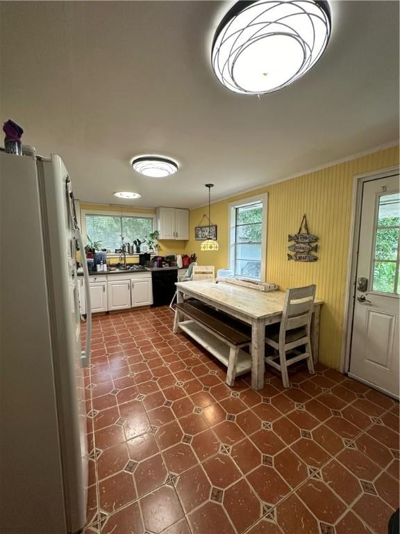 kitchen with pendant lighting, white refrigerator, and dark tile patterned flooring