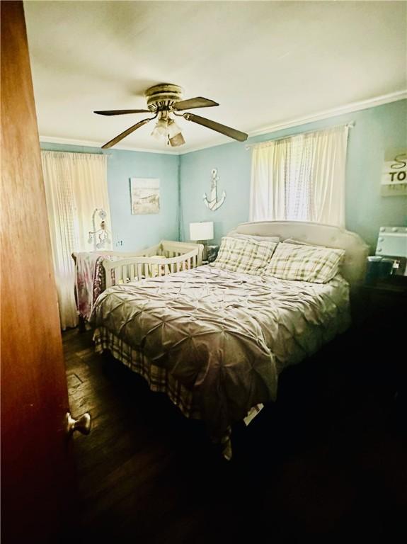 bedroom featuring wood-type flooring, ceiling fan, and crown molding