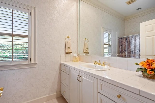 bathroom featuring vanity, crown molding, and a wealth of natural light