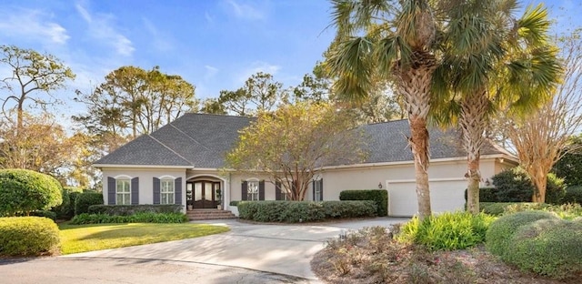 view of front of home with french doors, a front yard, and a garage