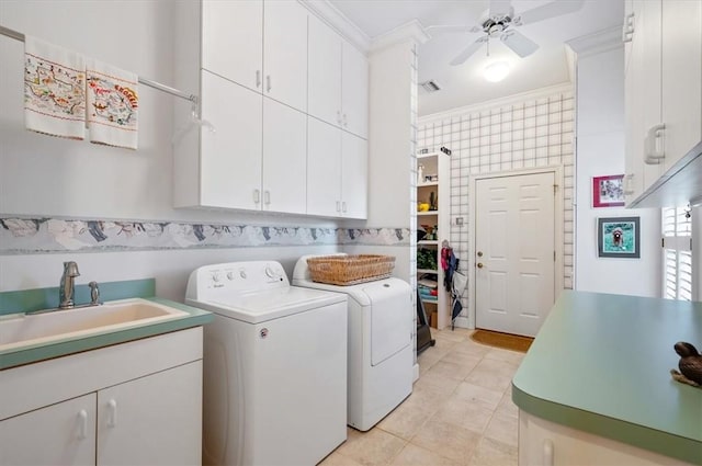 laundry room featuring ceiling fan, sink, cabinets, washer and dryer, and ornamental molding