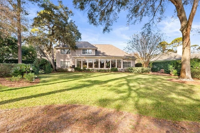 back of house with a sunroom and a yard