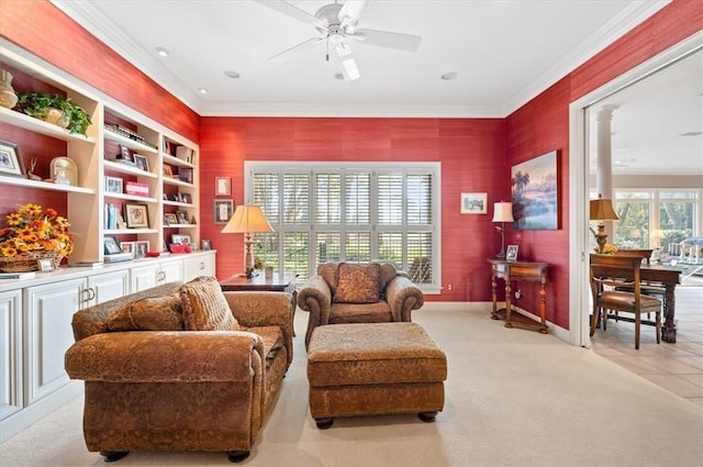 living area with crown molding, ceiling fan, and light colored carpet