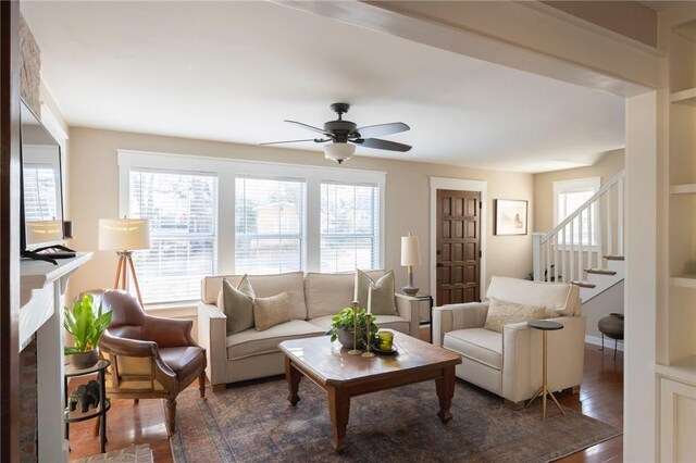 living room with ceiling fan, stairway, and wood finished floors