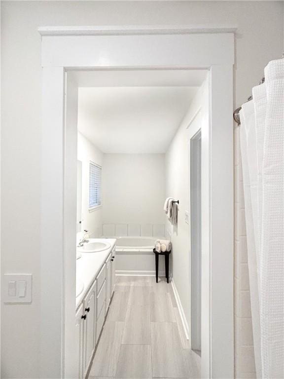 bathroom featuring a garden tub and vanity