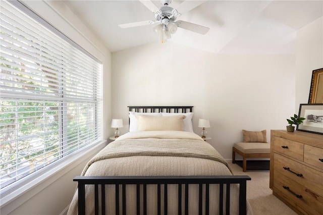 bedroom with a ceiling fan, light colored carpet, and vaulted ceiling