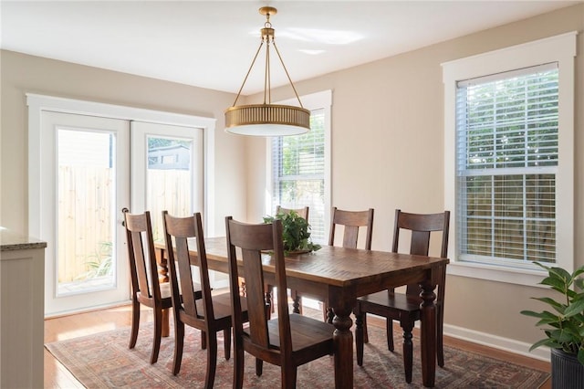 dining room with french doors, wood finished floors, and baseboards