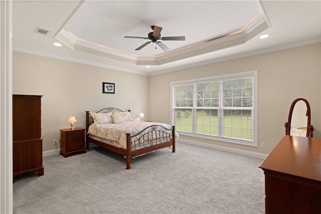 bedroom with light colored carpet, ceiling fan, a raised ceiling, and ornamental molding