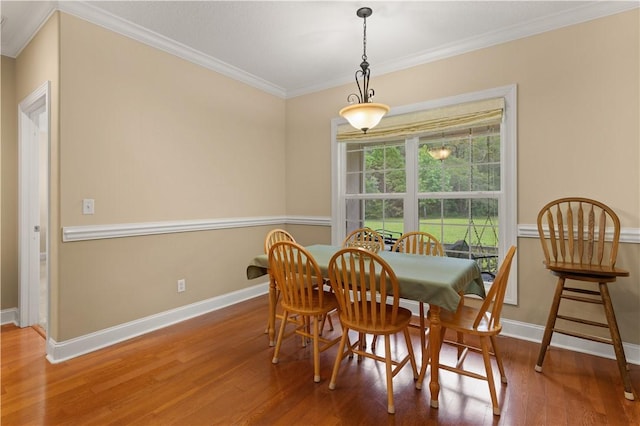 dining area with hardwood / wood-style floors and ornamental molding