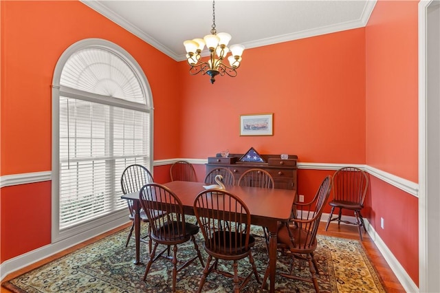 dining area with crown molding, hardwood / wood-style floors, and a notable chandelier