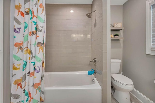 bathroom with shower / bath combo, baseboards, and toilet