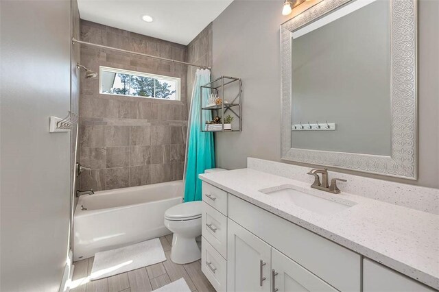 bathroom with toilet, shower / bathtub combination with curtain, and vanity