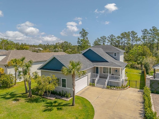 view of front of property with fence, an attached garage, concrete driveway, a front lawn, and a porch