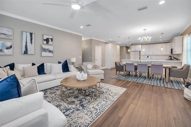 living area featuring dark wood finished floors, visible vents, and crown molding